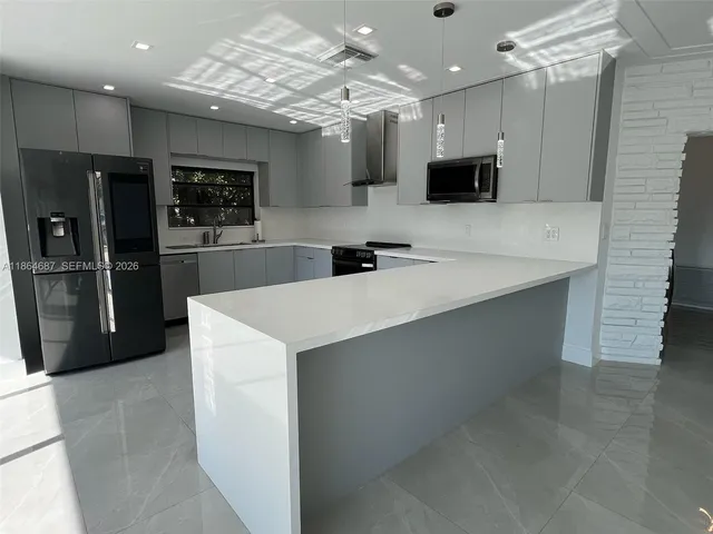 a kitchen with kitchen island a sink stainless steel appliances and cabinets
