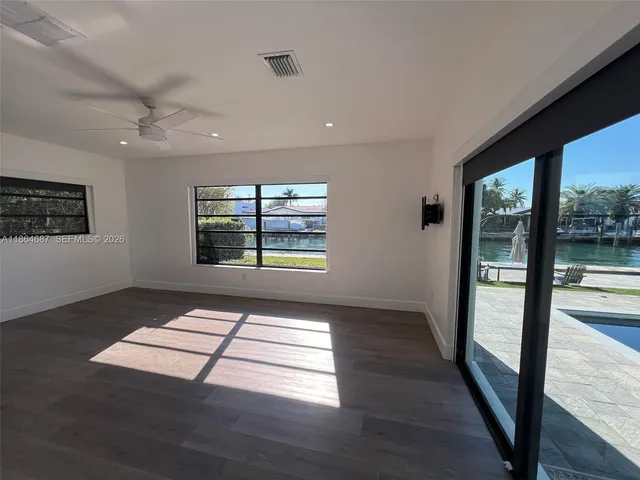 a view of an empty room with glass door and windows