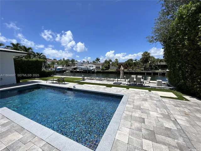 a view of swimming pool with outdoor seating and yard in back