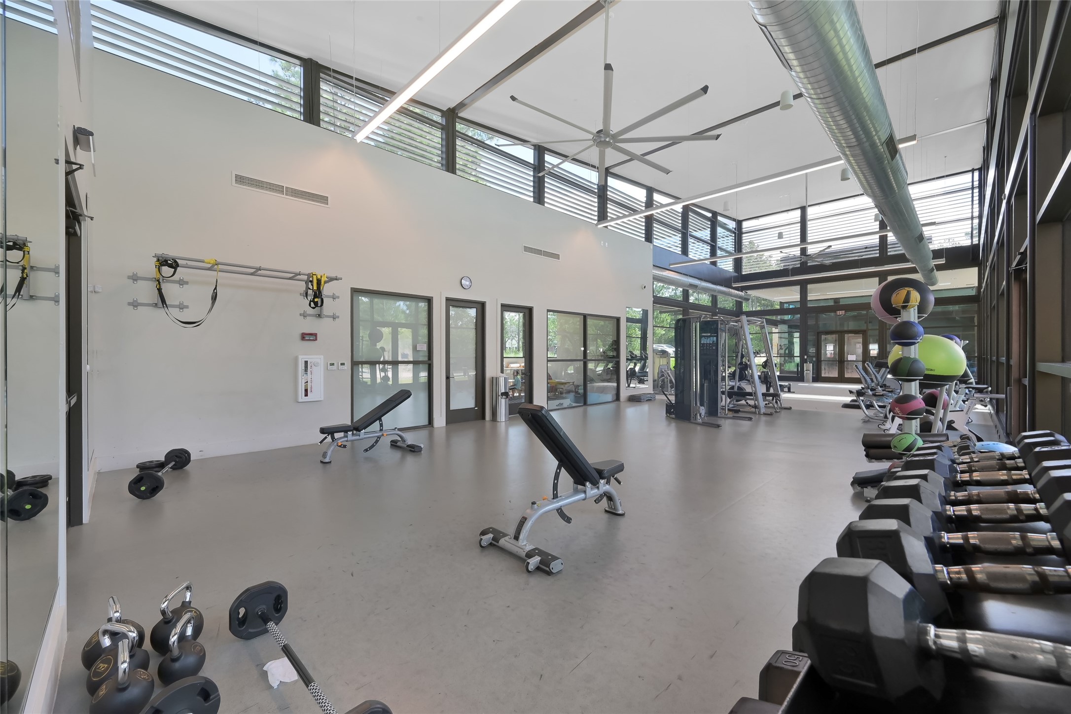 111 Yellow Perch Way Conroe, TX 77318 - Photo 29 of 35 Modern fitness center equipped for a variety of workout routines, featuring a dedicated children's room, yoga lawn, and a multipurpose space for classes and virtual instruction.