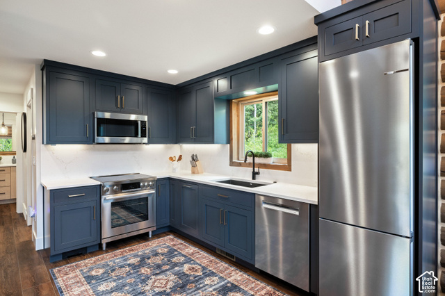 917 West Deep Forest Road Coalville, UT 84017 - Photo 9 of 41 Full-height navy cabinetry, white countertops, stainless steel appliances, wood-finish flooring, and a black sink with a matte black faucet