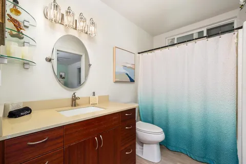 a bathroom with a sink vanity mirror and toilet