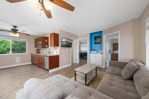 a kitchen with stainless steel appliances granite countertop a sink a stove a refrigerator cabinets and wooden floor