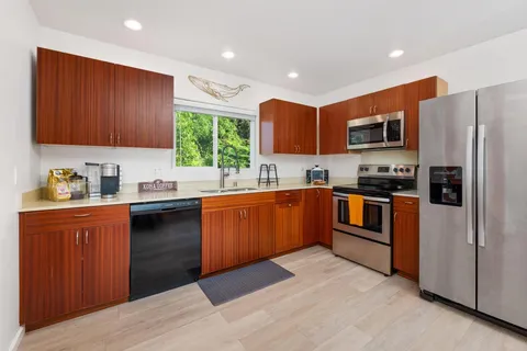 a kitchen with stainless steel appliances granite countertop a refrigerator sink and stove