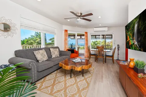 a living room with furniture flat screen tv and a large window