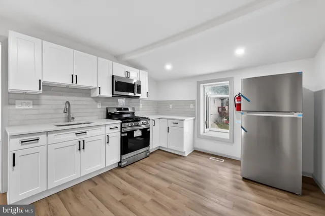 a kitchen with a refrigerator and a stove top oven