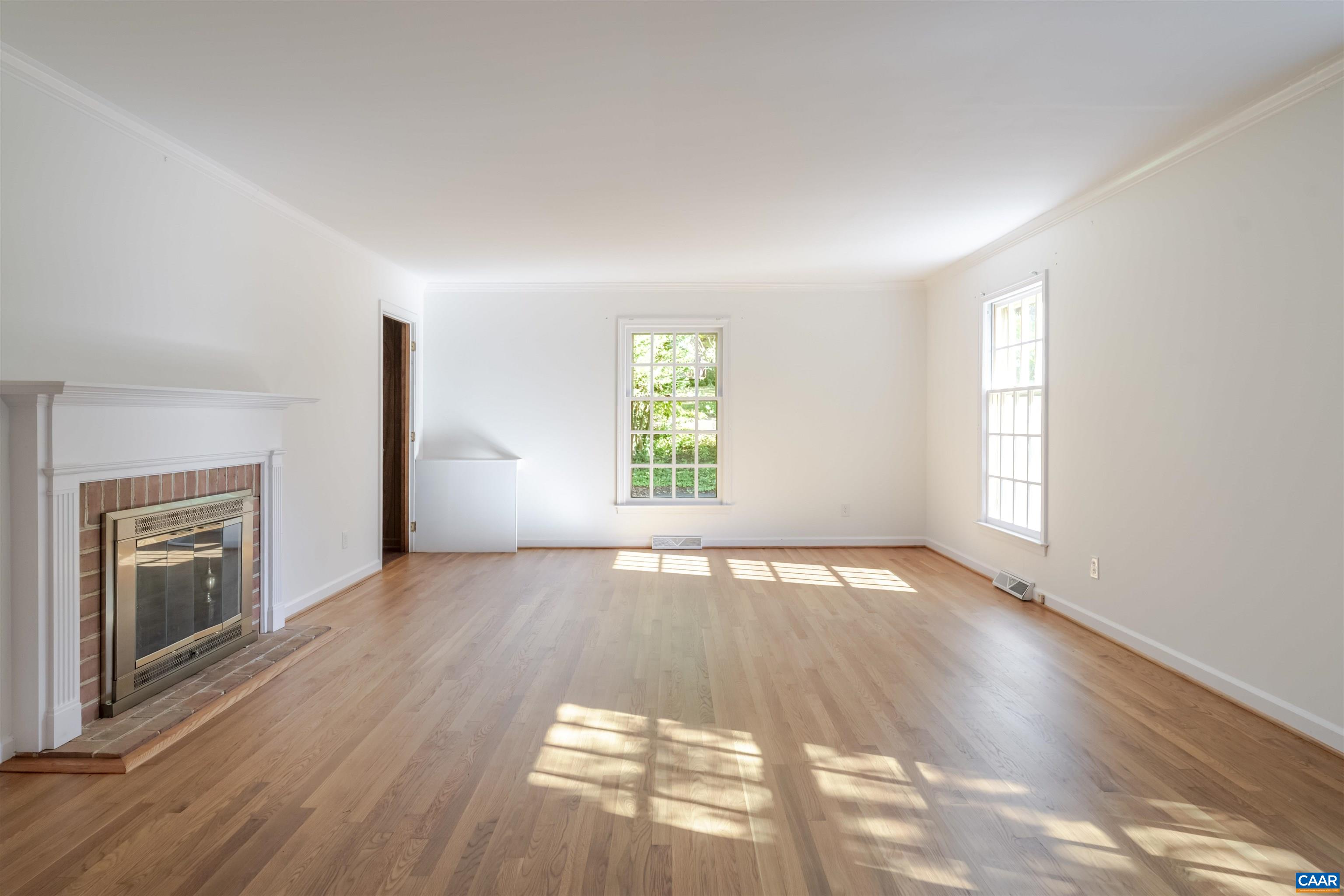 207 Surrey Road Charlottesville, VA 22901 - Photo 7 of 38 A spacious & beautiful room with gorgeous white oak hardwood floors, nice natural light, a wood burning fireplace and built-in bookshelves.
