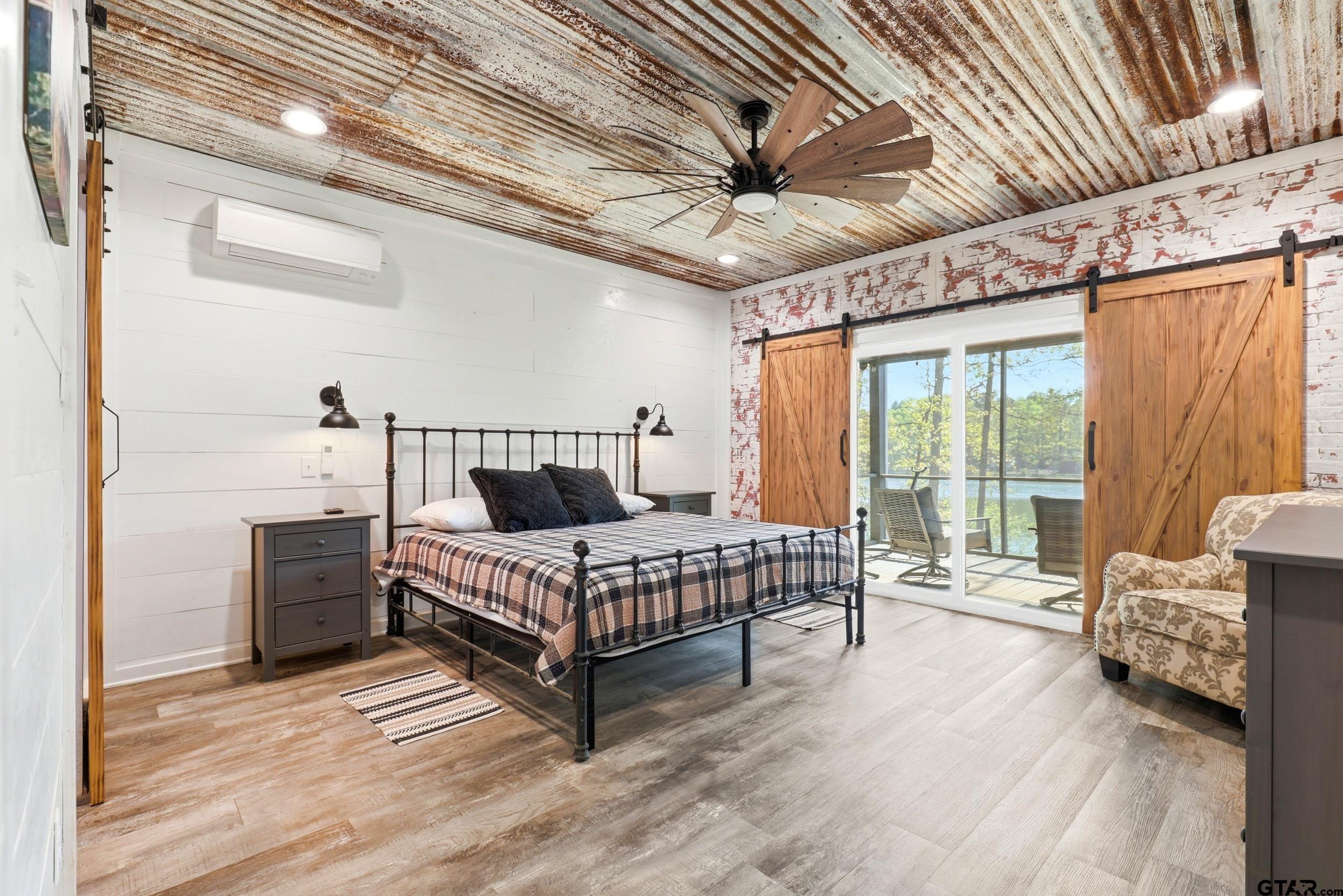 132 King George Road Scroggins, TX 75480 - Photo 12 of 35 a spacious bedroom with a bed couch and a ceiling fan