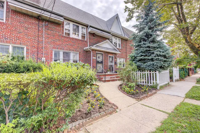 a front view of a house with a garden and plants
