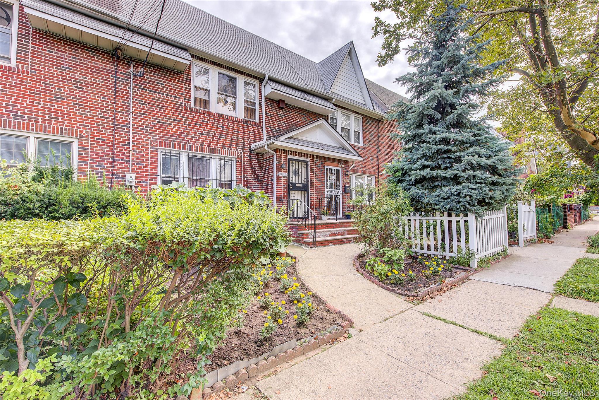 161-10 84th Road Queens, NY 11432 - Photo 1 of 44 a front view of a house with a garden and plants