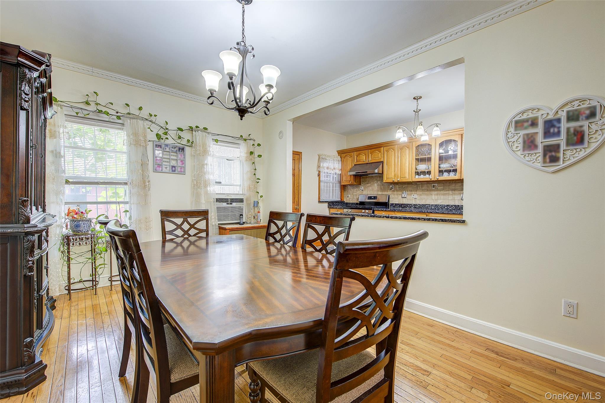 161-10 84th Road Queens, NY 11432 - Photo 13 of 44 a dining room with wooden floor a chandelier a wooden table and chairs