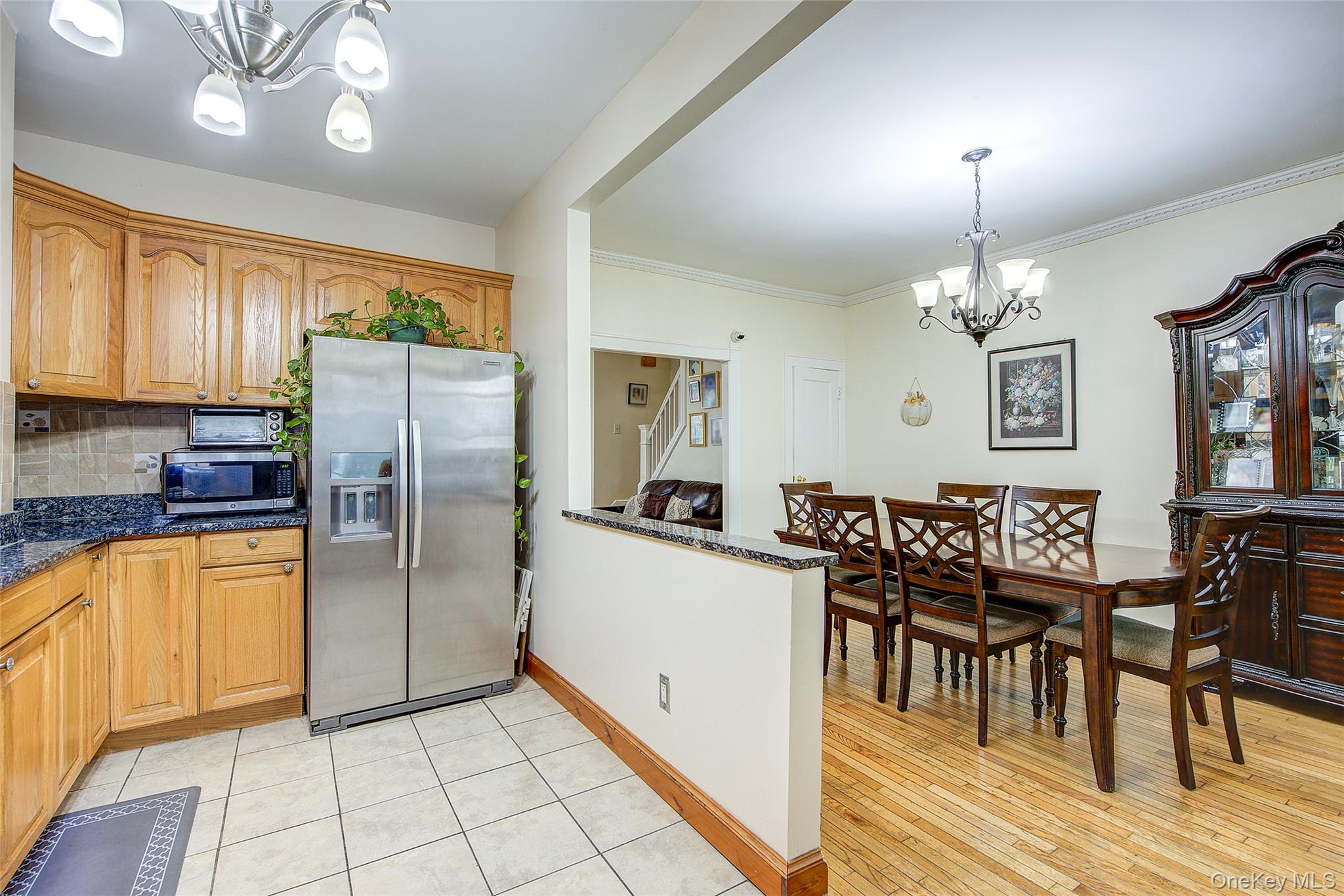 161-10 84th Road Queens, NY 11432 - Photo 18 of 44 a kitchen with stainless steel appliances granite countertop a refrigerator a stove a sink dishwasher with a dining table and chairs