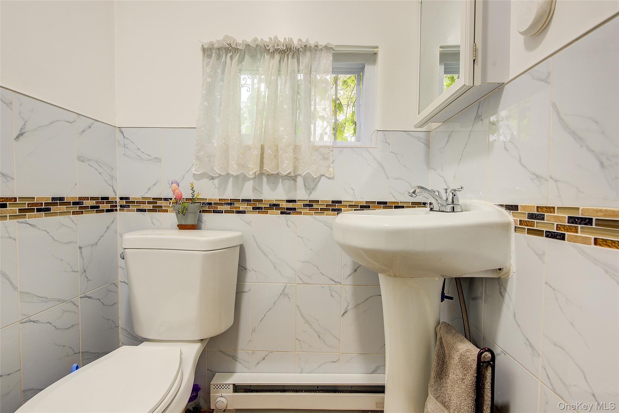 161-10 84th Road Queens, NY 11432 - Photo 20 of 44 a bathroom with a sink a toilet and a mirror