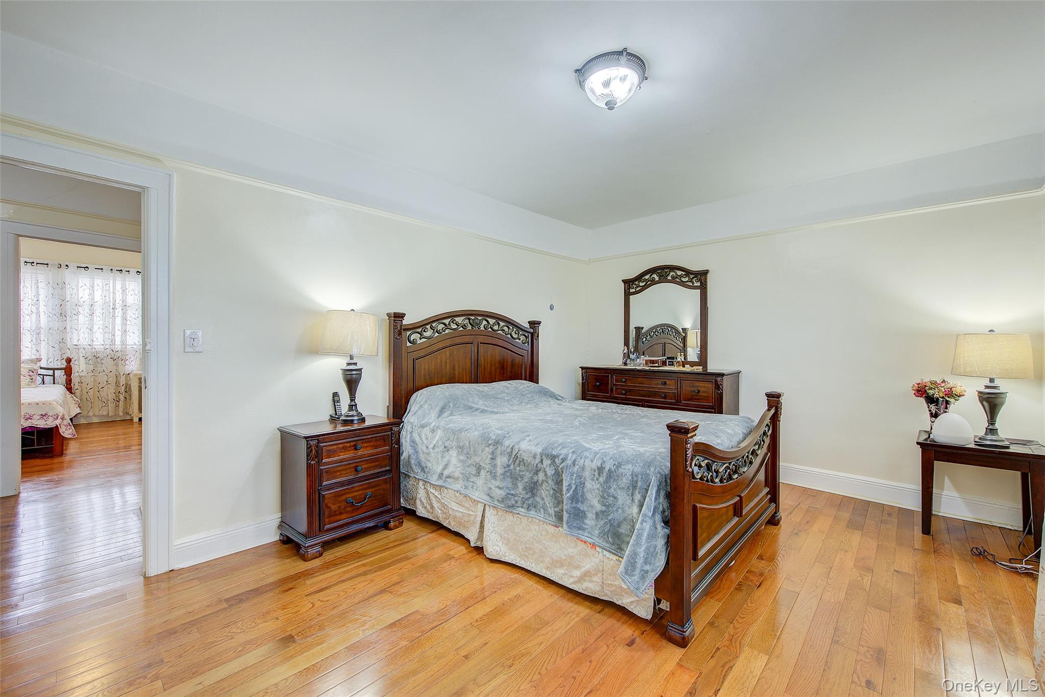 161-10 84th Road Queens, NY 11432 - Photo 27 of 44 a bedroom with a bed and a table
