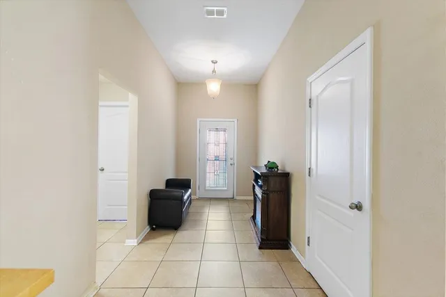 a view of a hallway with closet and a bathroom