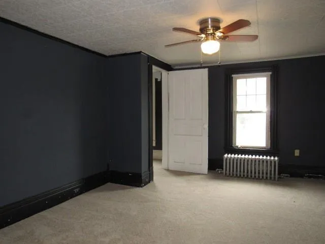an empty room with a window and a ceiling fan