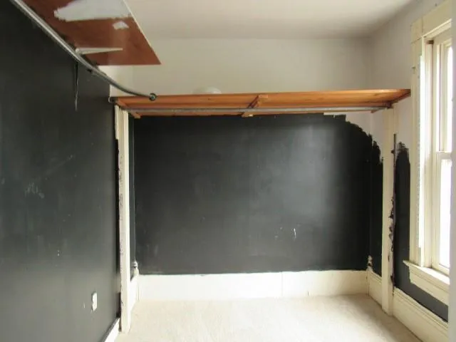 an empty room with closet and a chandelier fan