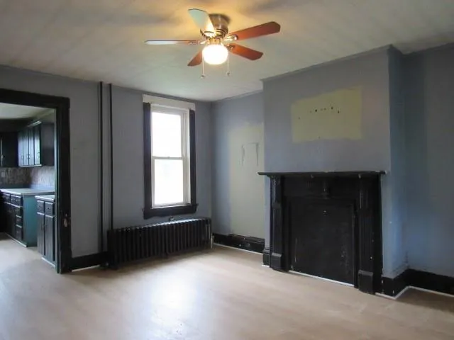 an empty room with windows and fan