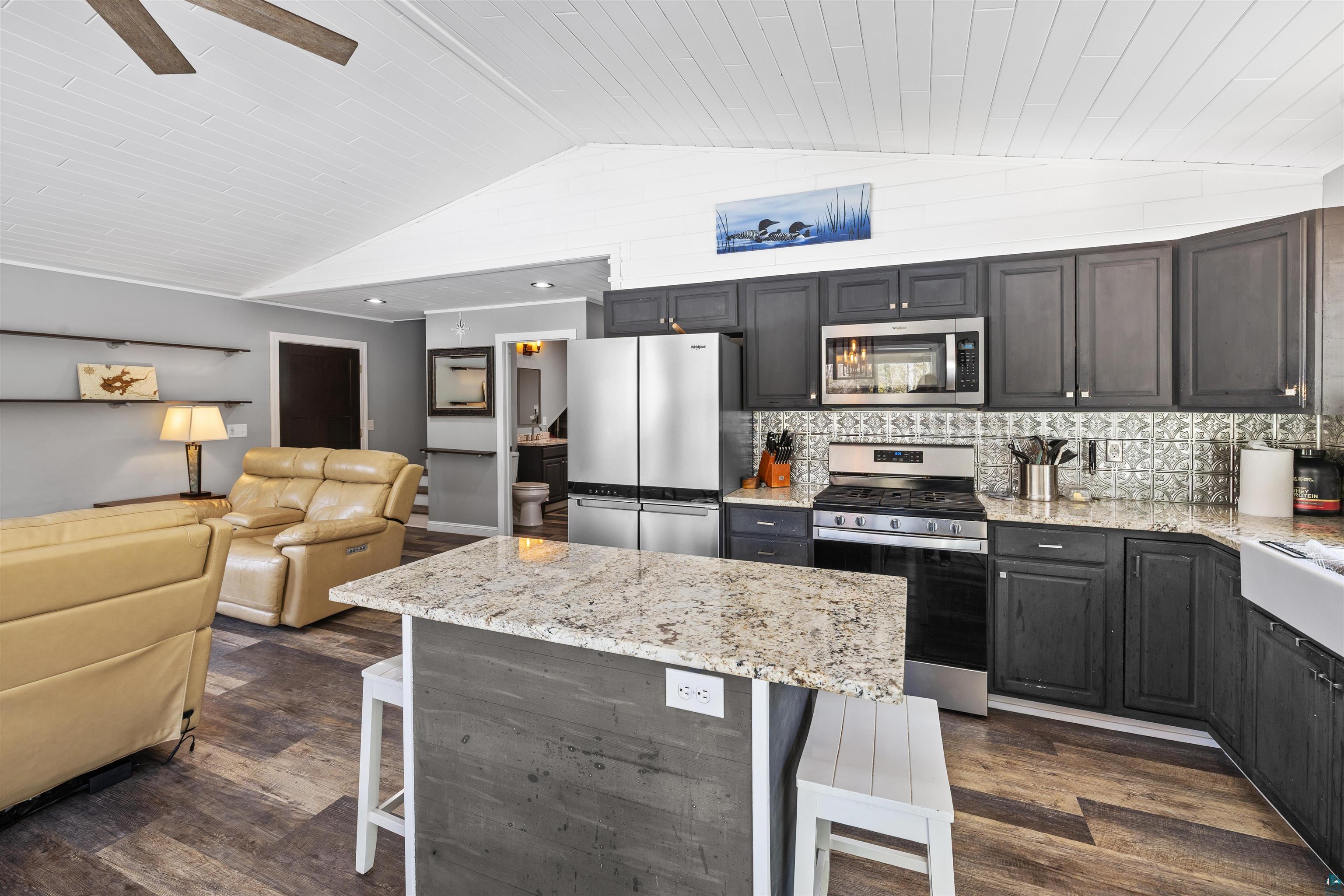 13462 Villa Road Ely, MN 55731 - Photo 5 of 68 Kitchen featuring a breakfast bar area, granite countertops, stainless steel appliances, Lifeproof flooring, and wooden ceiling