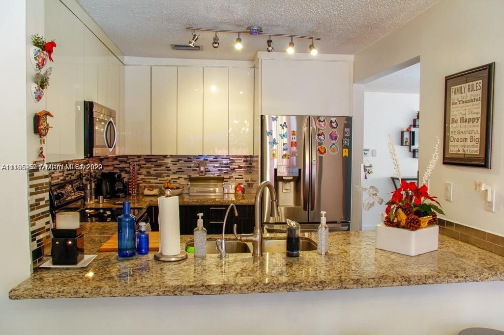 10000 Southwest 147th Court Miami, FL 33196 - Photo 12 of 36 a kitchen area with granite countertop a sink cabinets and appliances