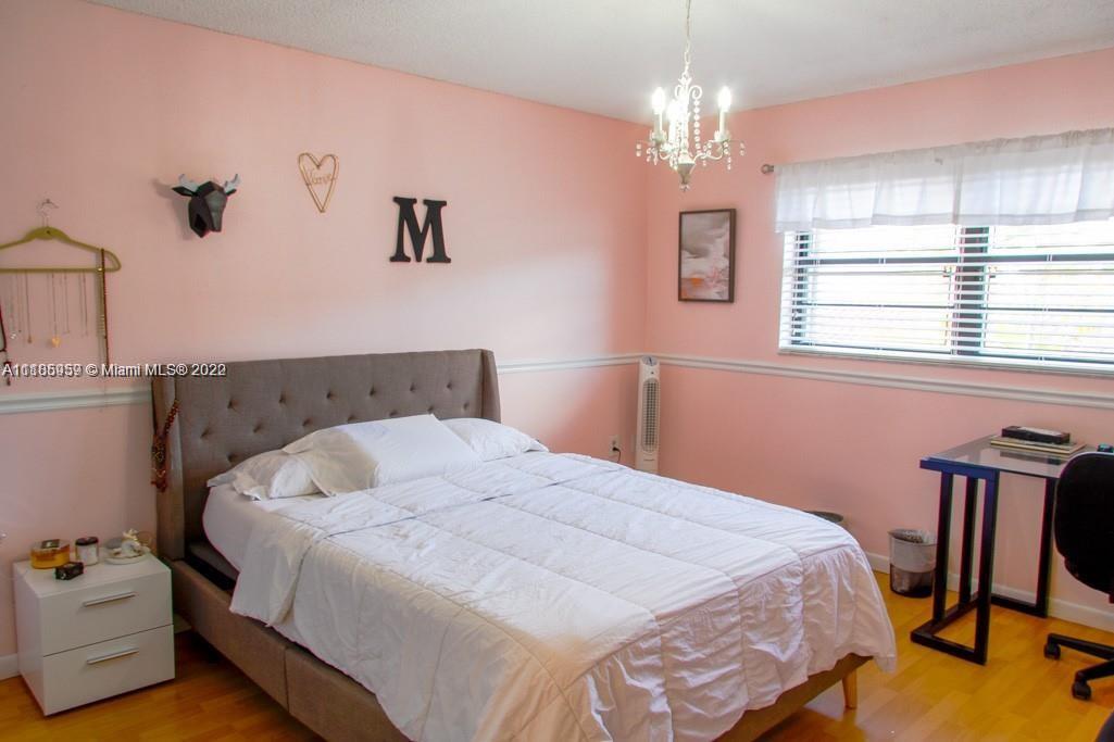 10000 Southwest 147th Court Miami, FL 33196 - Photo 22 of 36 a bedroom with a bed and a chandelier