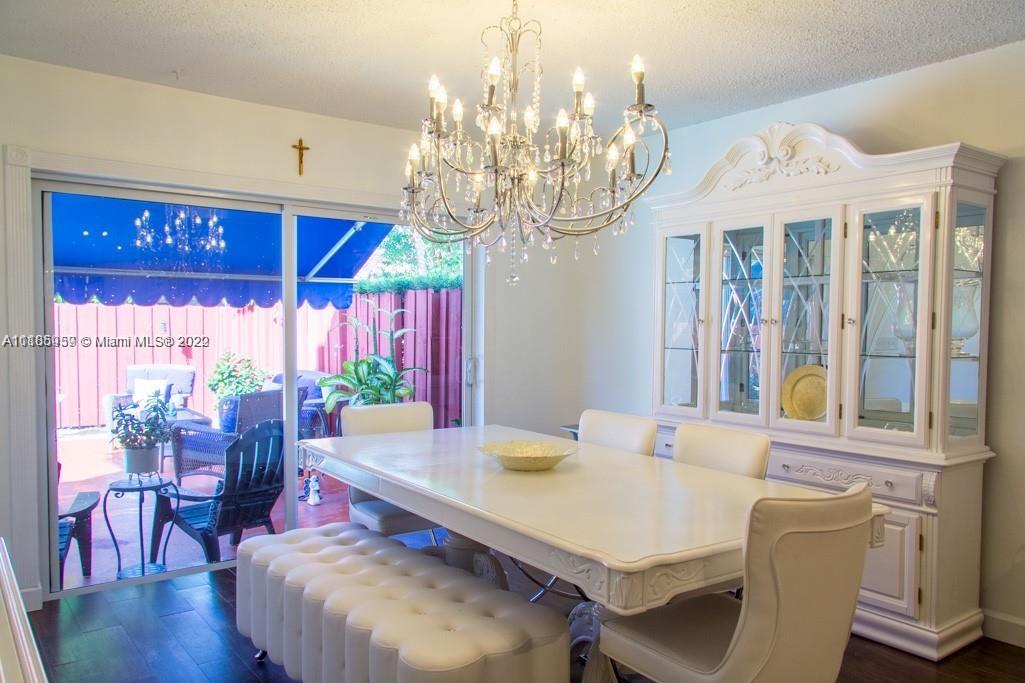 10000 Southwest 147th Court Miami, FL 33196 - Photo 9 of 36 a view of a dining room with furniture a chandelier and wooden floor
