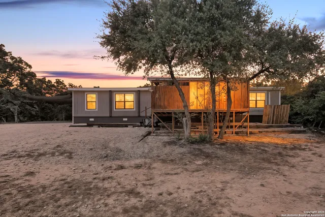 a view of a house with backyard and a tree