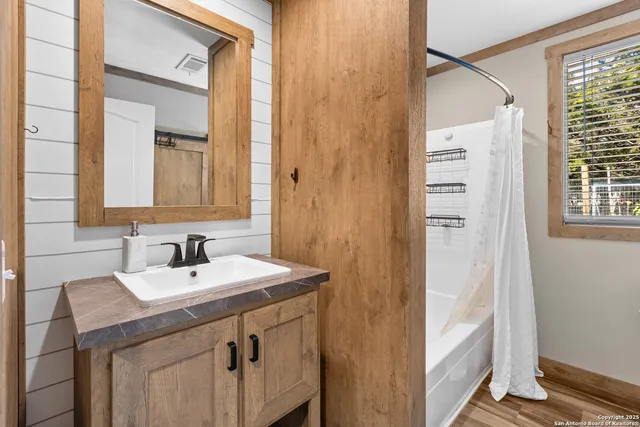 a bathroom with a sink a mirror and a shower