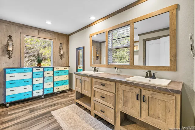 a spacious bathroom with a double vanity sink a mirror and a window