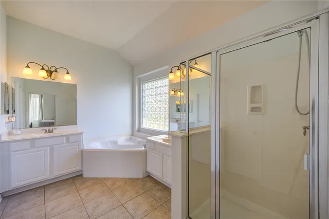 a bathroom with a tub sink and mirror