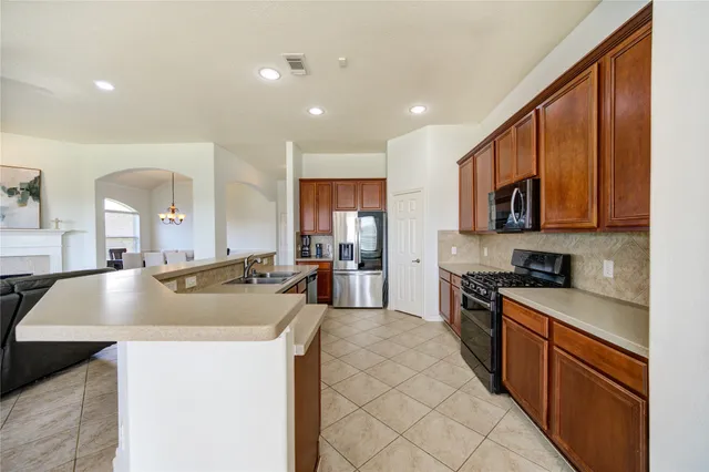 a kitchen with stainless steel appliances granite countertop a sink and a stove