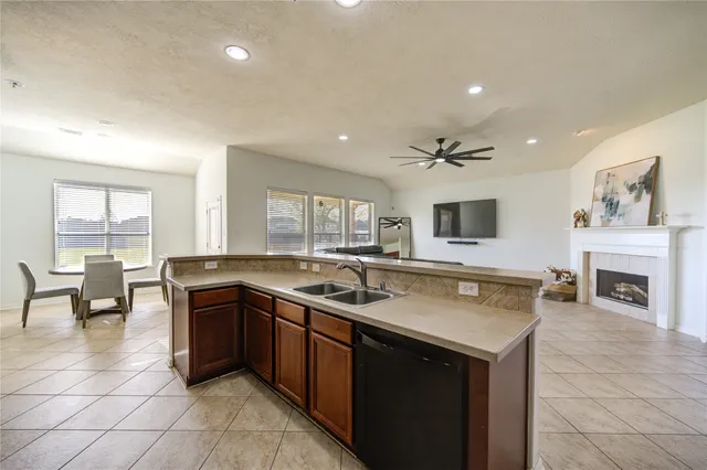 a kitchen with a sink and a stove top oven with wooden floor