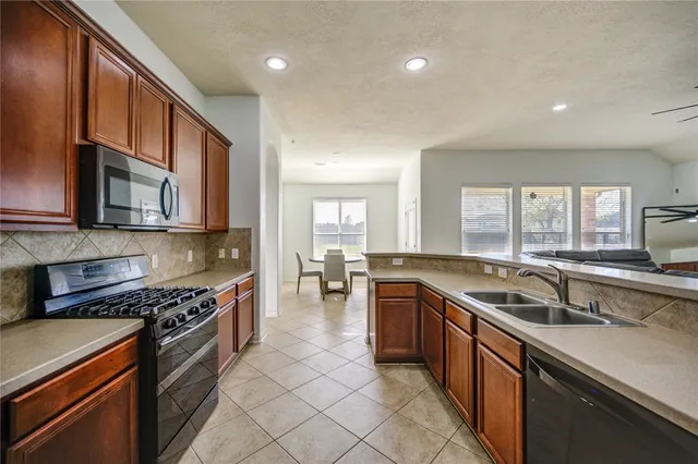 a kitchen with stainless steel appliances granite countertop a sink stove and cabinets