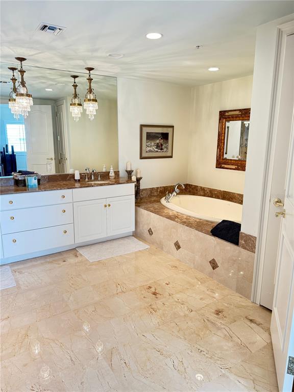 1111 Ritz Carlton Drive, Unit 1404 Sarasota, FL 34236 - Photo 32 of 69 a spacious bathroom with a tub sink and mirror