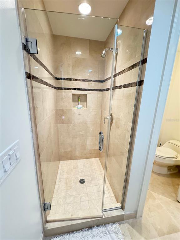 1111 Ritz Carlton Drive, Unit 1404 Sarasota, FL 34236 - Photo 45 of 69 a bathroom with a glass shower door and a mirror