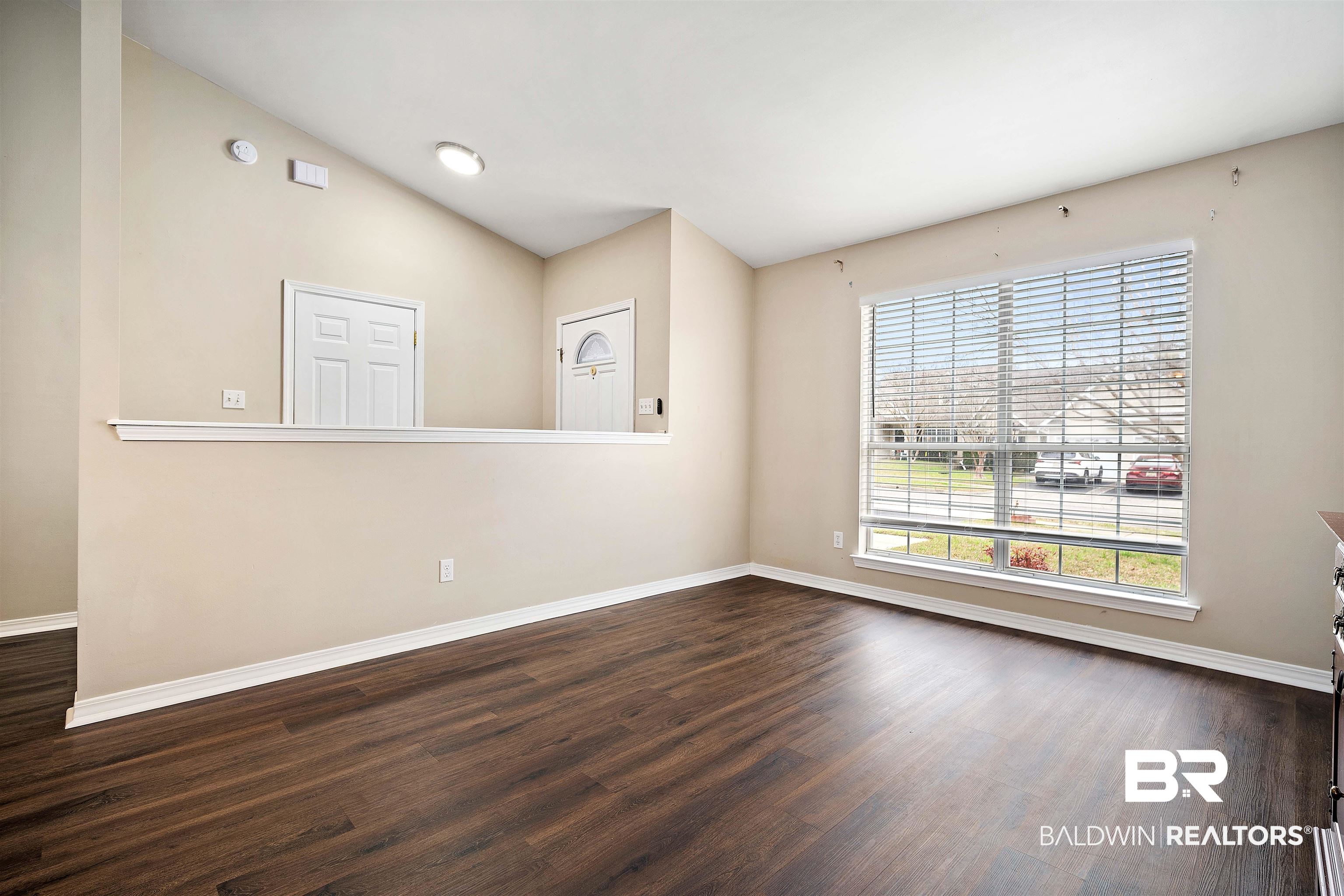 628 Spring Lake Court Mobile, AL 36695 - Photo 7 of 25 Unfurnished room with dark hardwood / wood-style flooring and vaulted ceiling