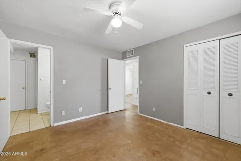 a view of an empty room and chandelier fan