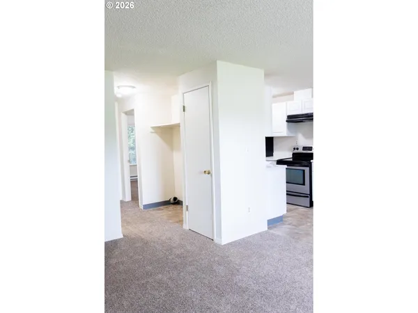 a view of kitchen with granite countertop cabinets and refrigerator