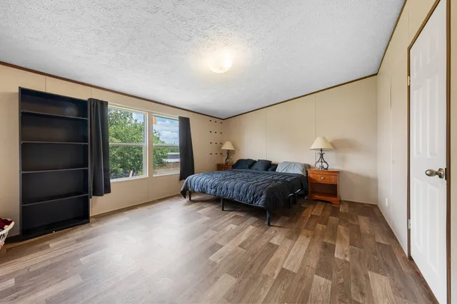 a bedroom with a bed and wooden floor