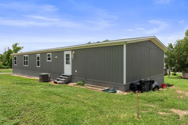 a backyard of a house with table and chairs