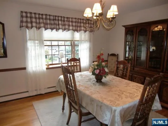 a view of a dining room with furniture a chandelier and large windows