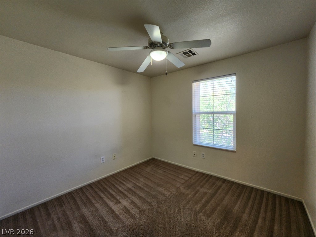 9132 Ripple Ridge Avenue, Unit 102 Las Vegas, NV 89149 - Photo 15 of 42 Spare room featuring dark carpet, ceiling fan, and a textured ceiling