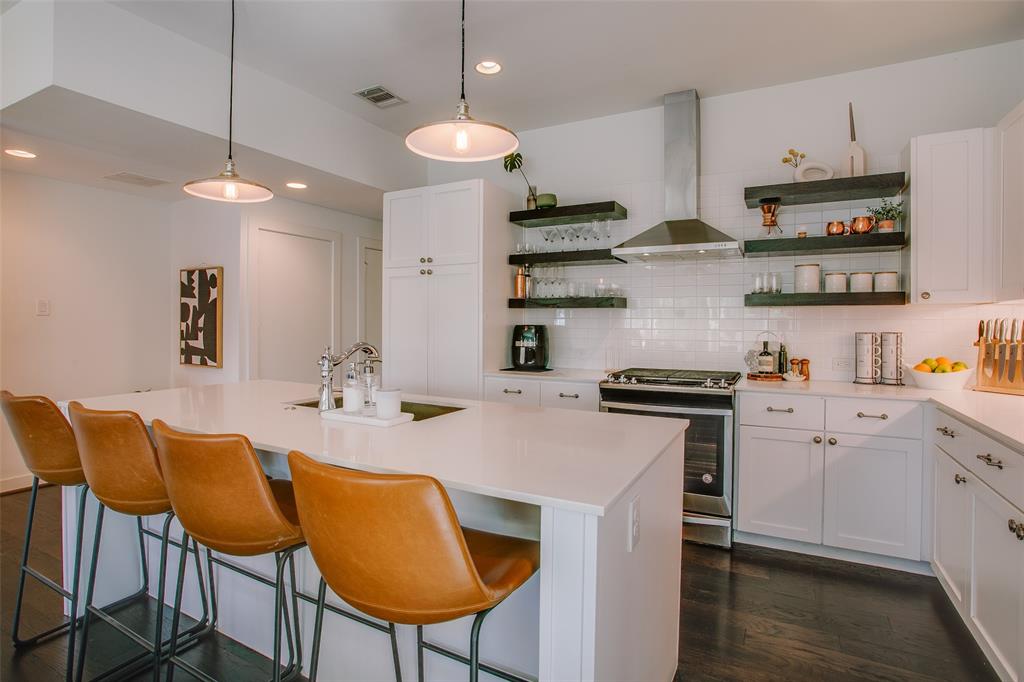 603 Finley Court Dallas, TX 75208 - Photo 7 of 40 a kitchen with stainless steel appliances kitchen island granite countertop a table chairs in it and wooden floors