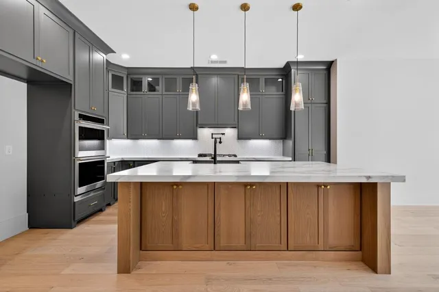 a kitchen with stainless steel appliances granite countertop a stove a sink and a refrigerator