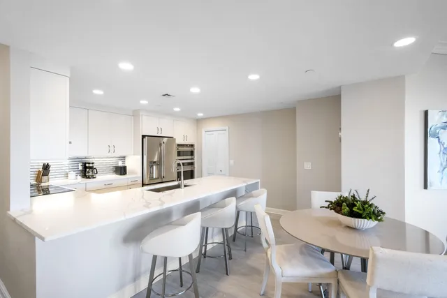 a kitchen with kitchen island a sink table and chairs