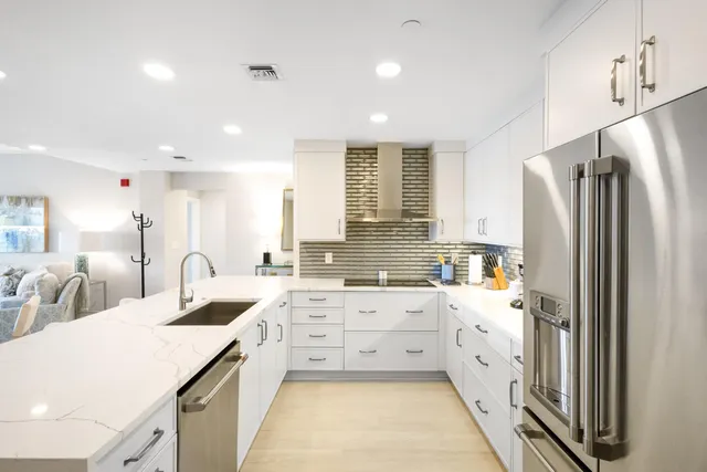 a large kitchen with a large counter top space appliances and cabinets