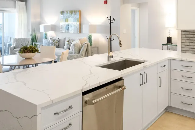 a kitchen with granite countertop white cabinets and white appliances
