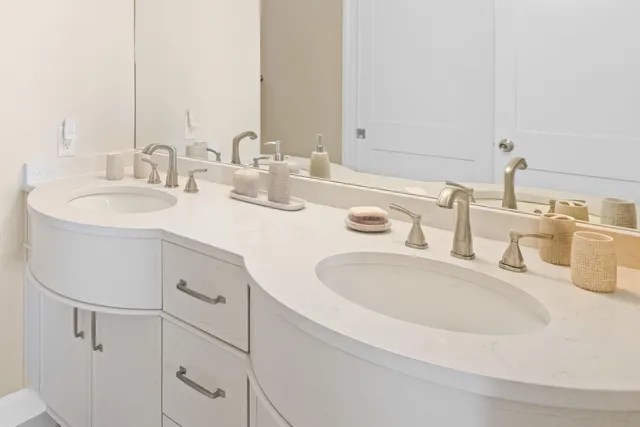a bathroom with double vanity sink and a mirror