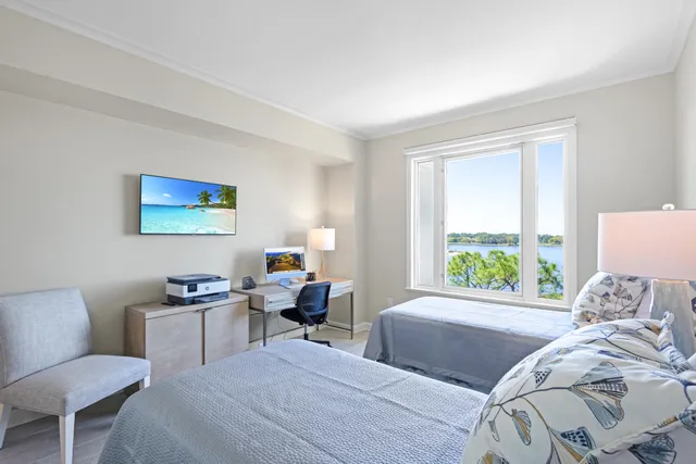 a bedroom with two beds and a large window