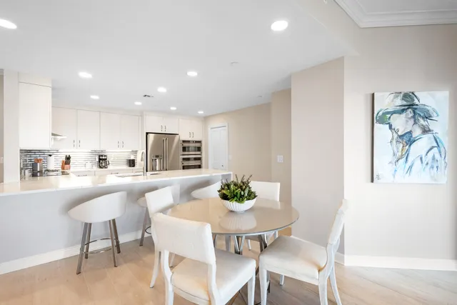 a kitchen with kitchen island a dining table and chairs